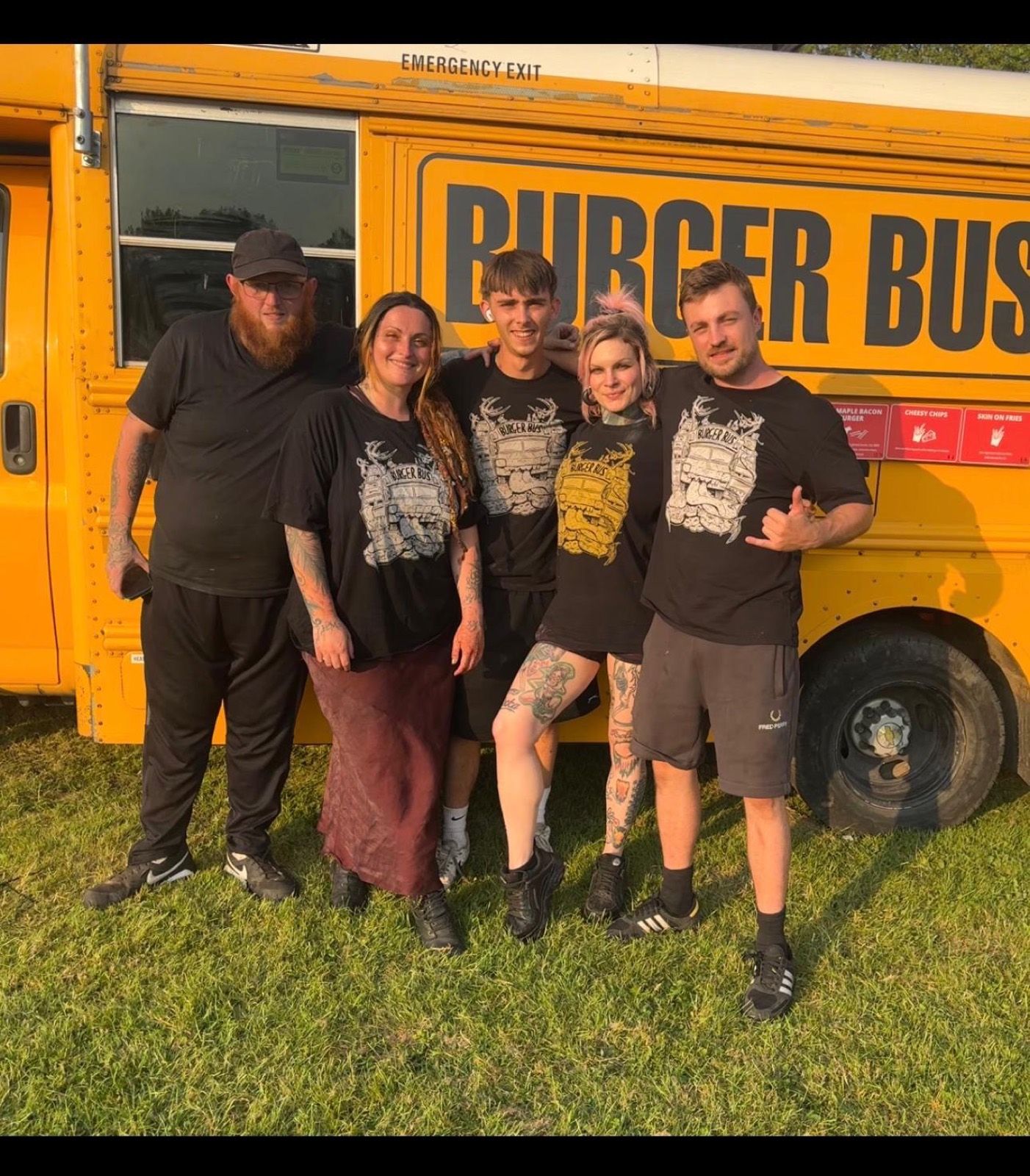 Five Burger Bus crew in matching shirts in front of the yellow bus